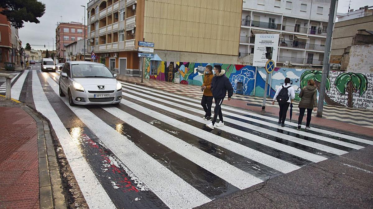 Un coche se detiene ante dos jóvenes en el paso de peatones gigante de Algemesí. | LEVANTE-EMV