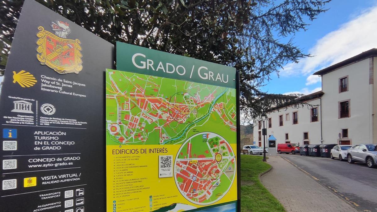 Panel con croquis de Grado, en la zona de la parada de taxi, al fondo de la imagen.