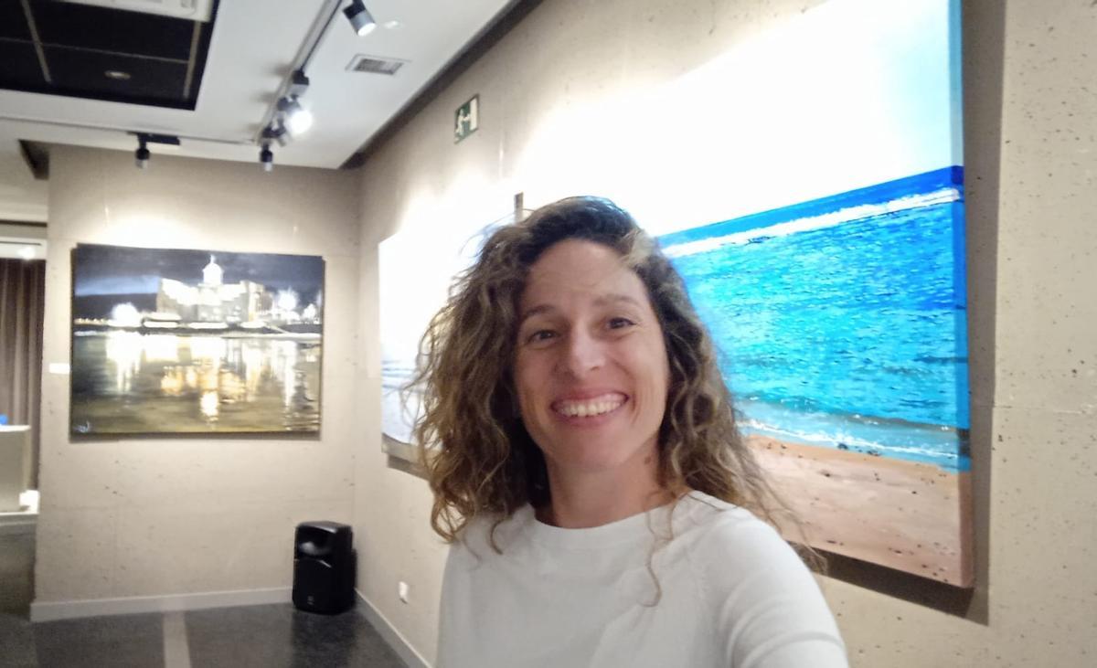Mejías, en la exposición y al fondo, una de su obra, el auditorio Alfredo Kraus.