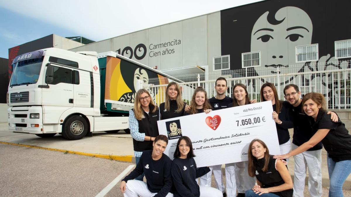 Once trabajadores de Carmencita muestran un cheque con la donación a Alicante Gastronómica.