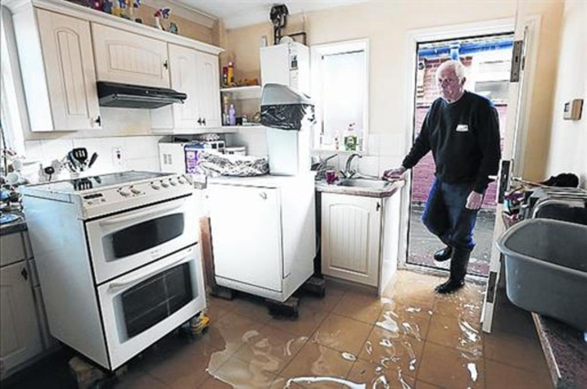 Michael Simmonds, d’Eghan, a la cuina de casa seva, inundada. Michael Simmonds, d’Eghan, a la cuina de casa seva, inundada.