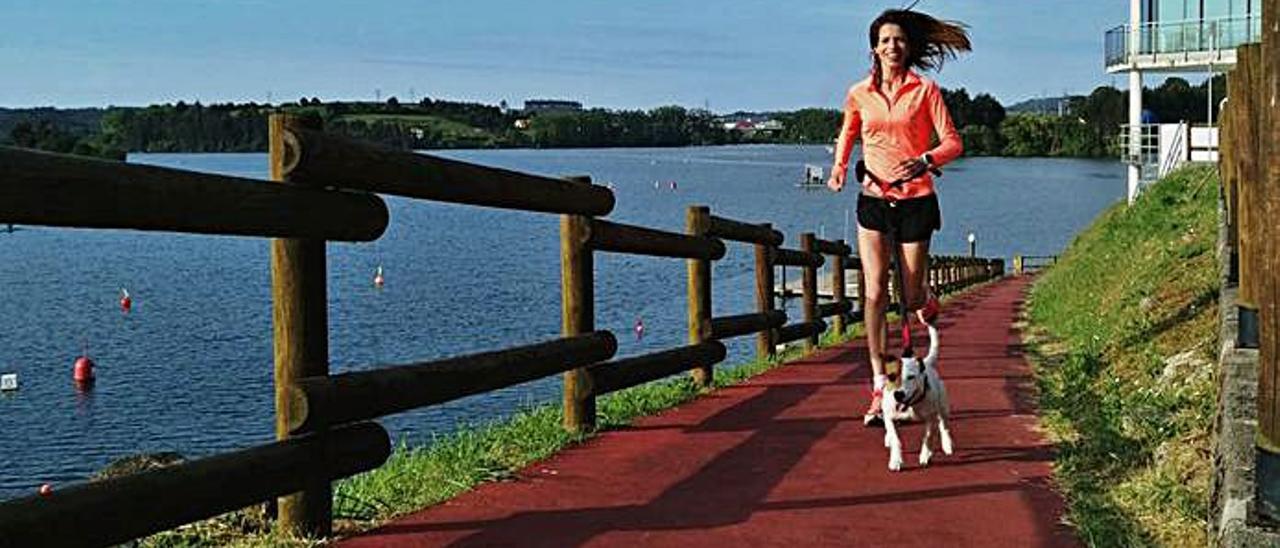 Vanessa Suárez, corriendo junto a su perro en el embalse de Trasona.