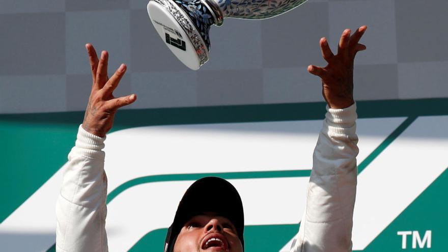 Hamilton con el trofeo nada más conseguir un nuevo triunfo.