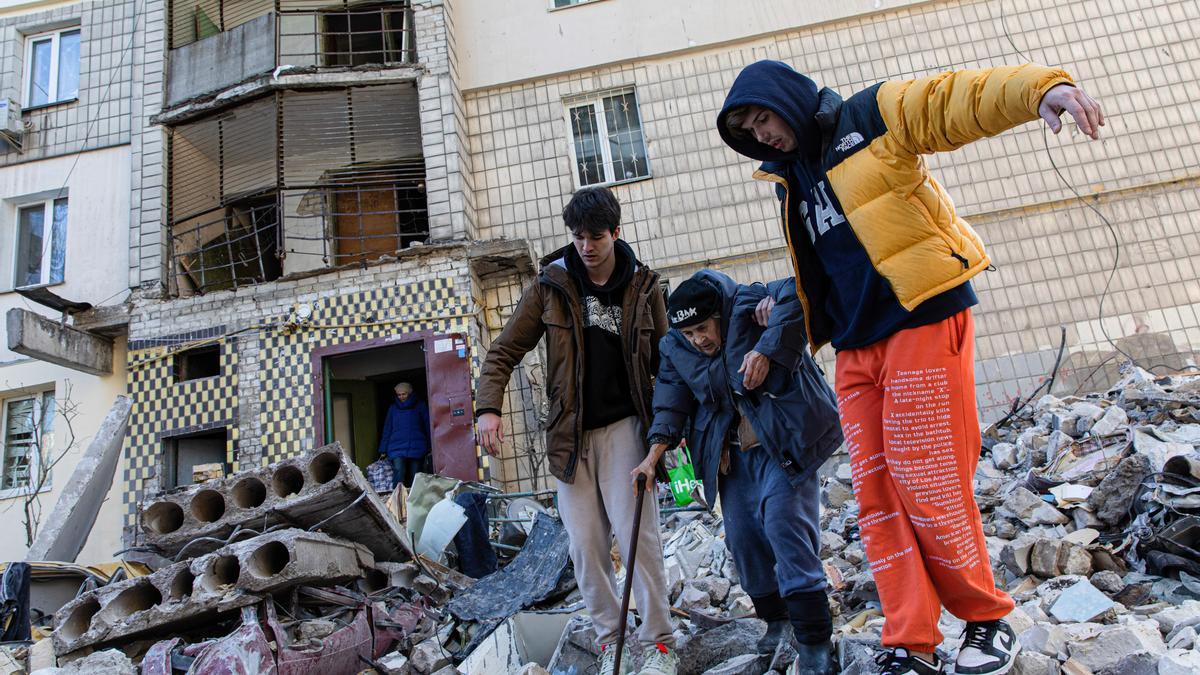 Dos civiles ayudan a otra persona en Kiev.