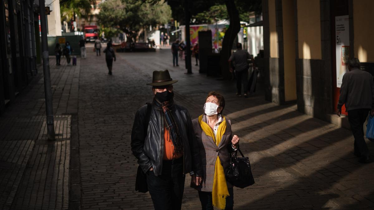 Una pareja con mascarilla pasea por las calles de Santa Cruz de Tenerife.