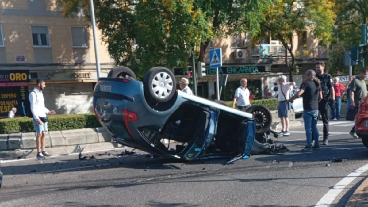 Uno de los dos coches ha quedado completamente volcado tras el aparatoso accidente, en la avenida de Libia con avenida de Barcelona.