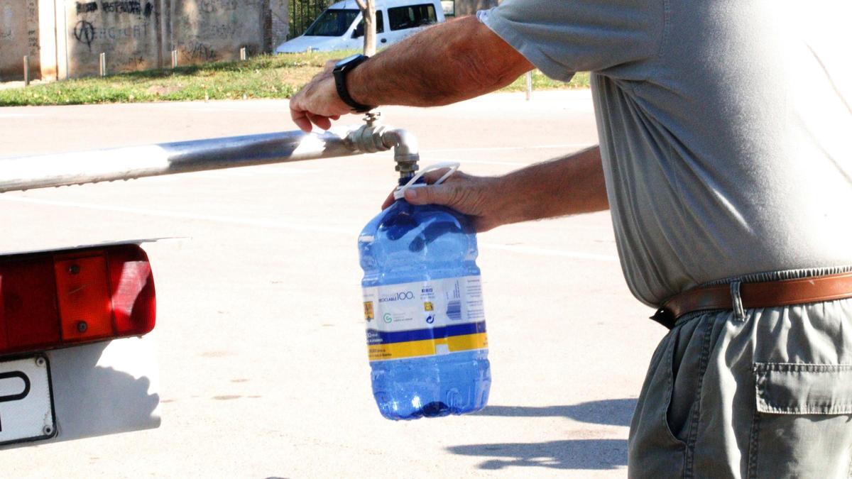 Un veí omplint una garrafa d'aigua a la Bisbal d'Empordà