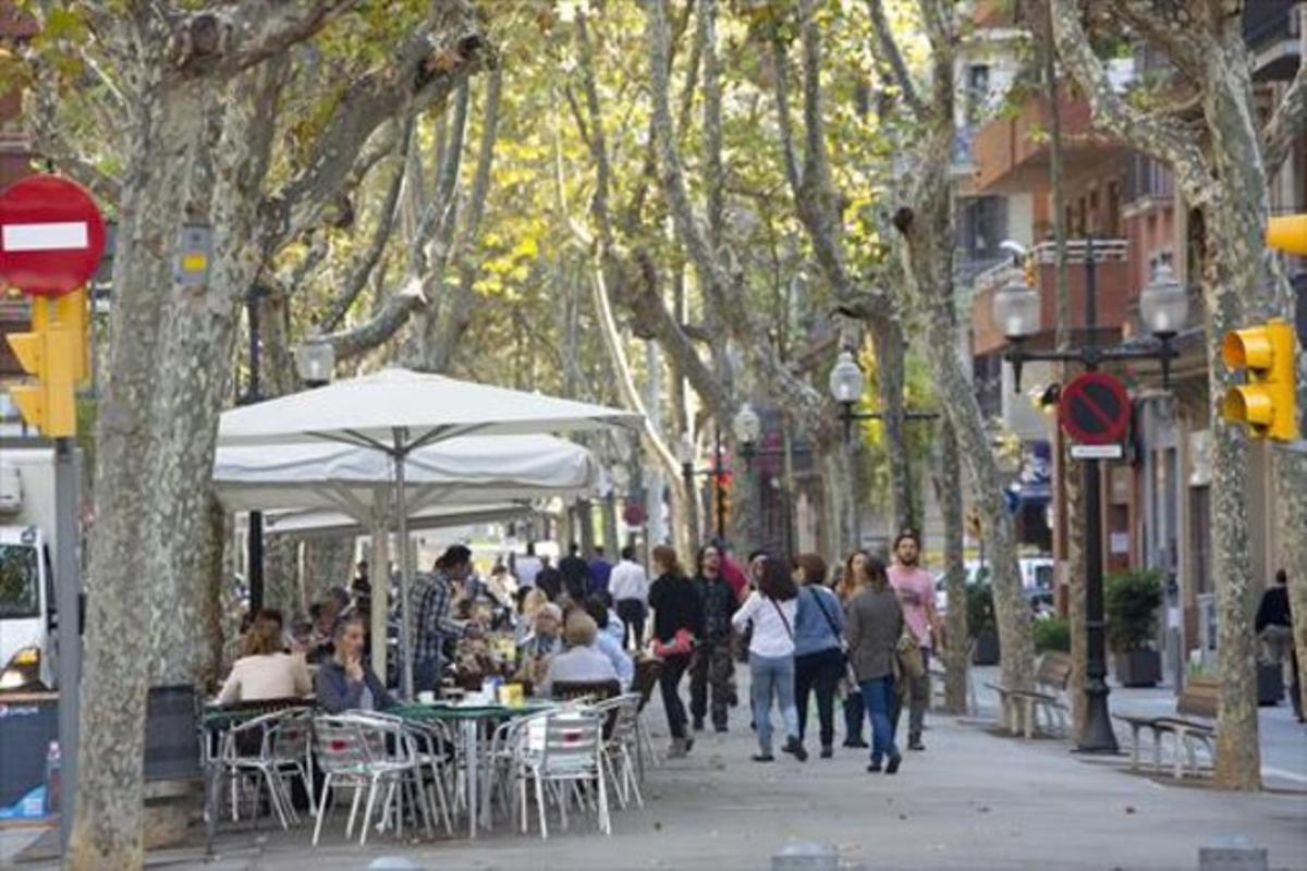 Transeünts passegen pel costat d’una de les terrasses de la rambla del Poblenou, la setmana passada.