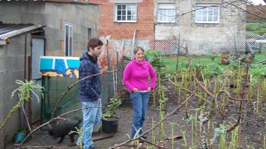 Lupe González, junto a su hijo, en la huerta de su casa en la que se encontró la planta de cannabis.  // Faro