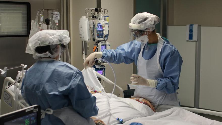 Dues infermeres atenent una pacient de covid-19 ingressada al servei de Medicina Intensiva de l&#039;Hospital de Tortosa Verge de la Cinta