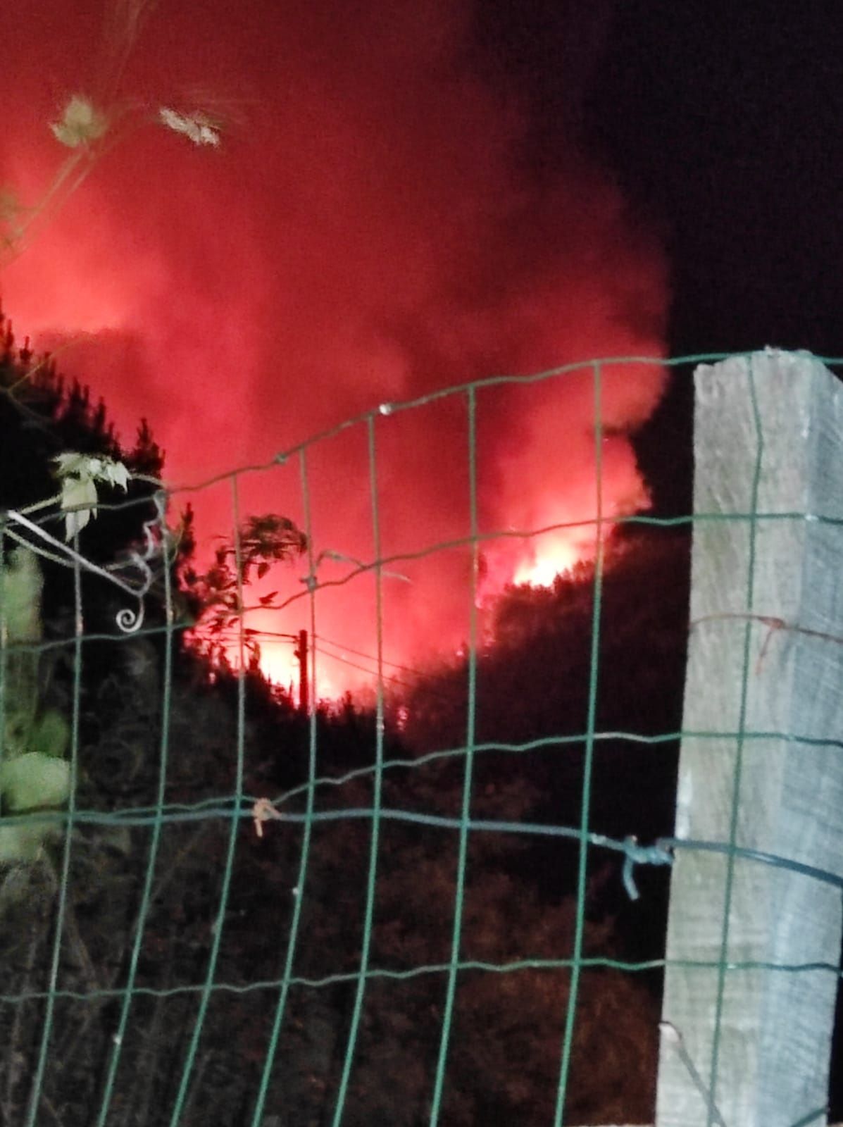 El fuego, antes de medianoche, acercándose a las casas.