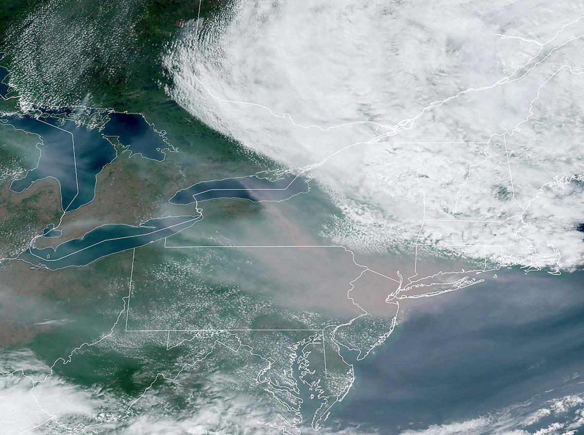 Imagen de satélite cortesía del Observatorio de la Tierra de la NASA donde se observa el humo de los incendios en Canadá desplazándose hacia Nueva York y Pennsylvania.