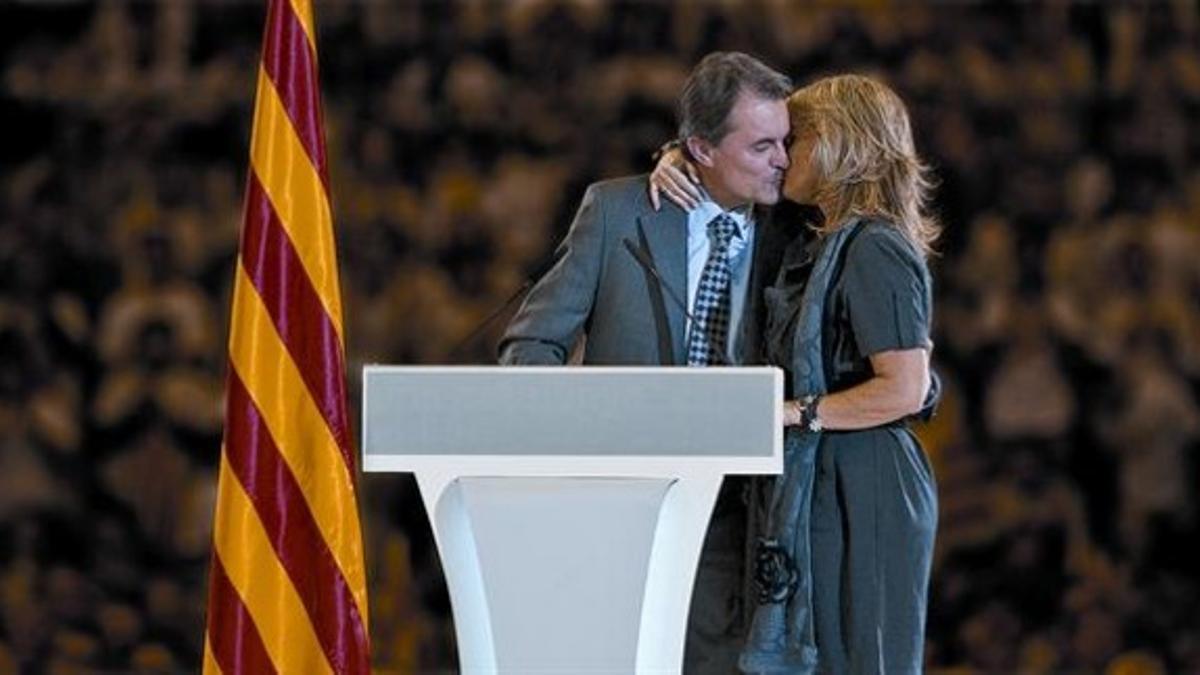 Artur Mas besa a su mujer, Helena Rakosnik, a la que dedicó parte de su mitin, ayer en el Palau Sant Jordi.