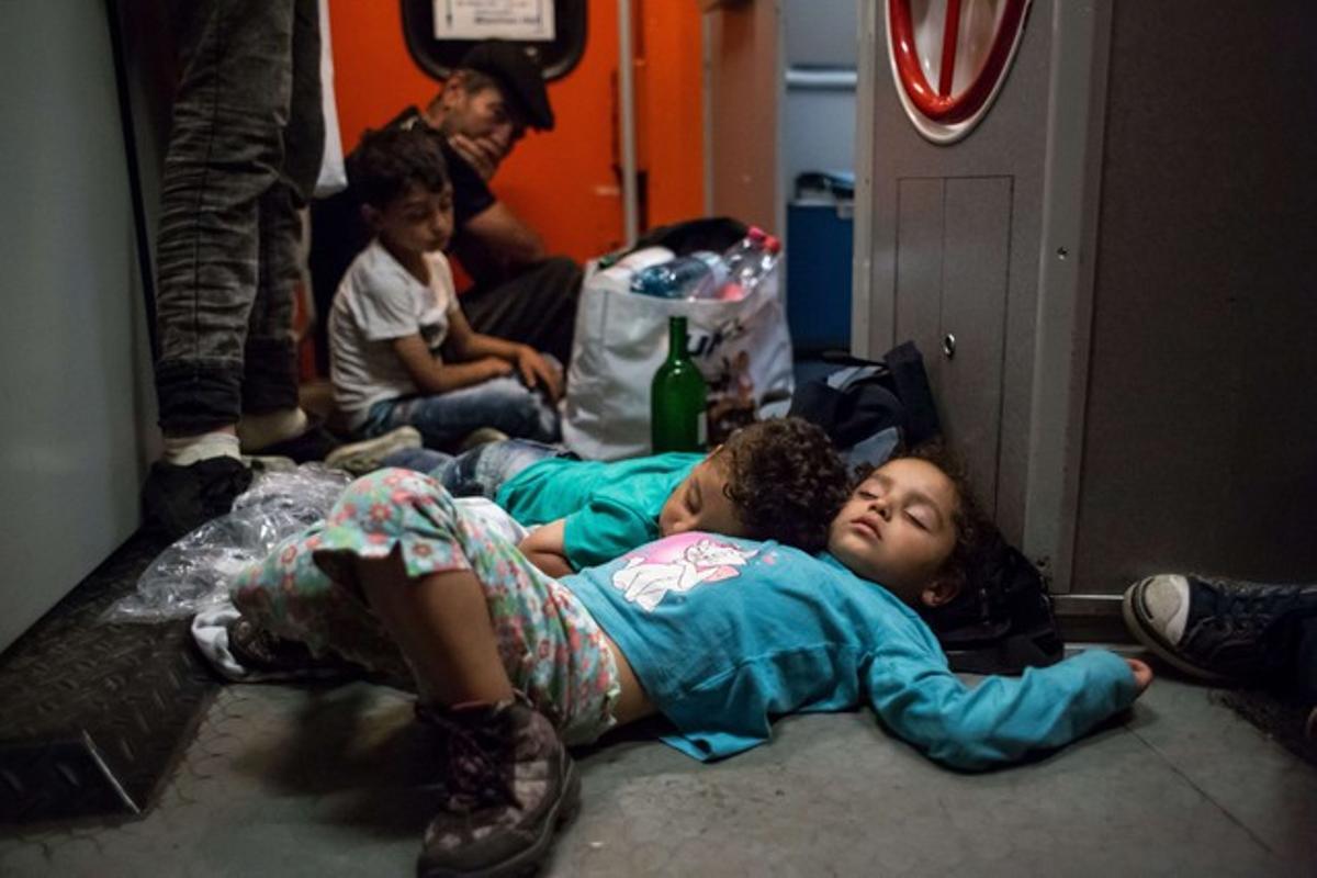 Unos niños duermen en la estación de trenes de Keleti mientras esperan poder viajar a Alemania desde Hungría.