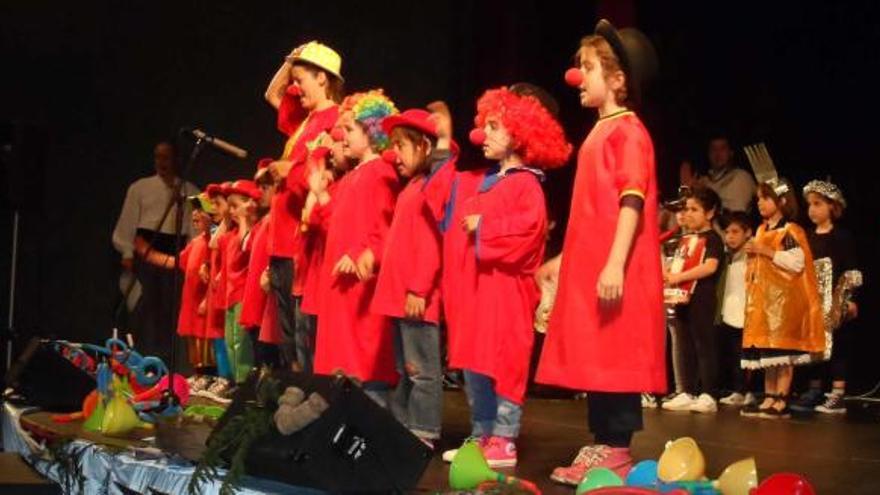 Los alumnos disfrazados de payasos, cantando. A la derecha, los niños bailan la danza prima.