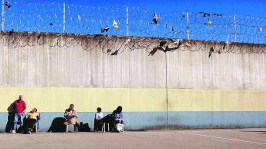 César Santiago Ruisánchez, en el patio de uno de los módulos de la cárcel de Villabona. Abajo, varios presos en una zona interior. | miki lópez