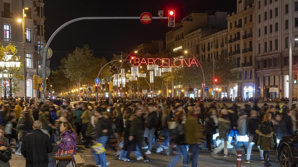 El centro de Barcelona abarrotado de gente bajo las luces de decoración de la Navidad.