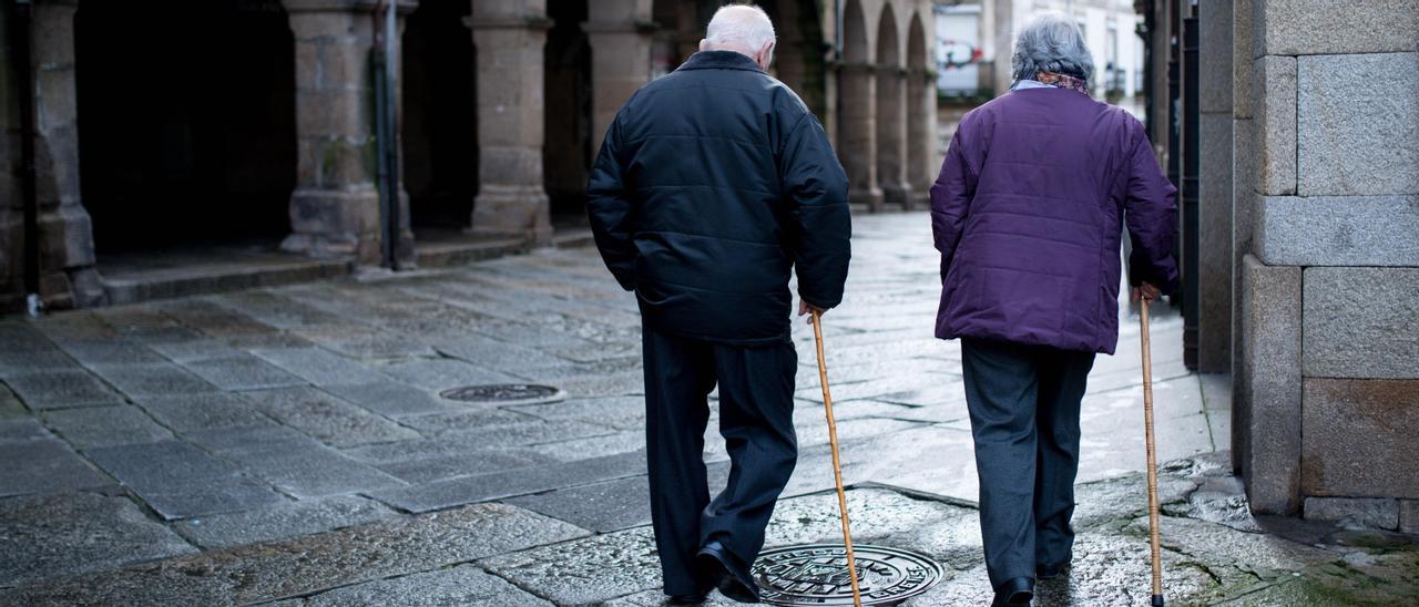 Dos personas mayores caminan en Ourense