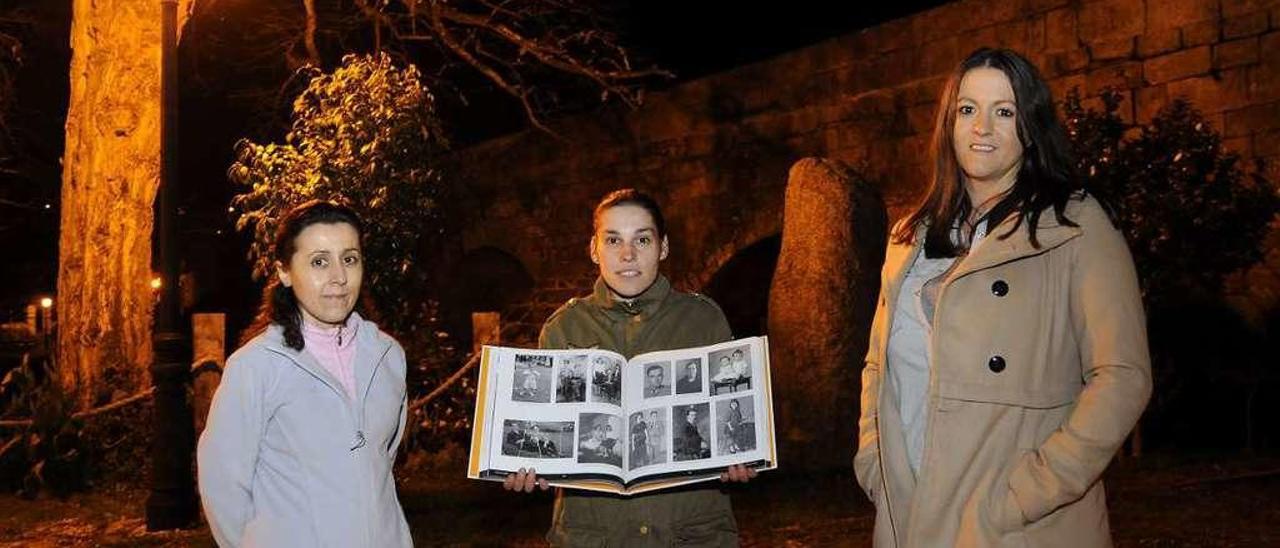 Alejandra, entre Natalí e Araceli, cun exemplar do libro diante da ponte de Gres. // Bernabé/Javier Lalín