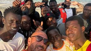 Damián Solé se hace un selfie con los migrantes poco después de que llegarán a la playa donde trabaja.