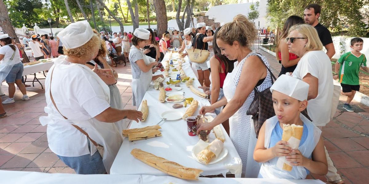 Cientos de personas, especialmente niños y sus familias, participan en la peculiar elaboración del bocadillo gigante.
