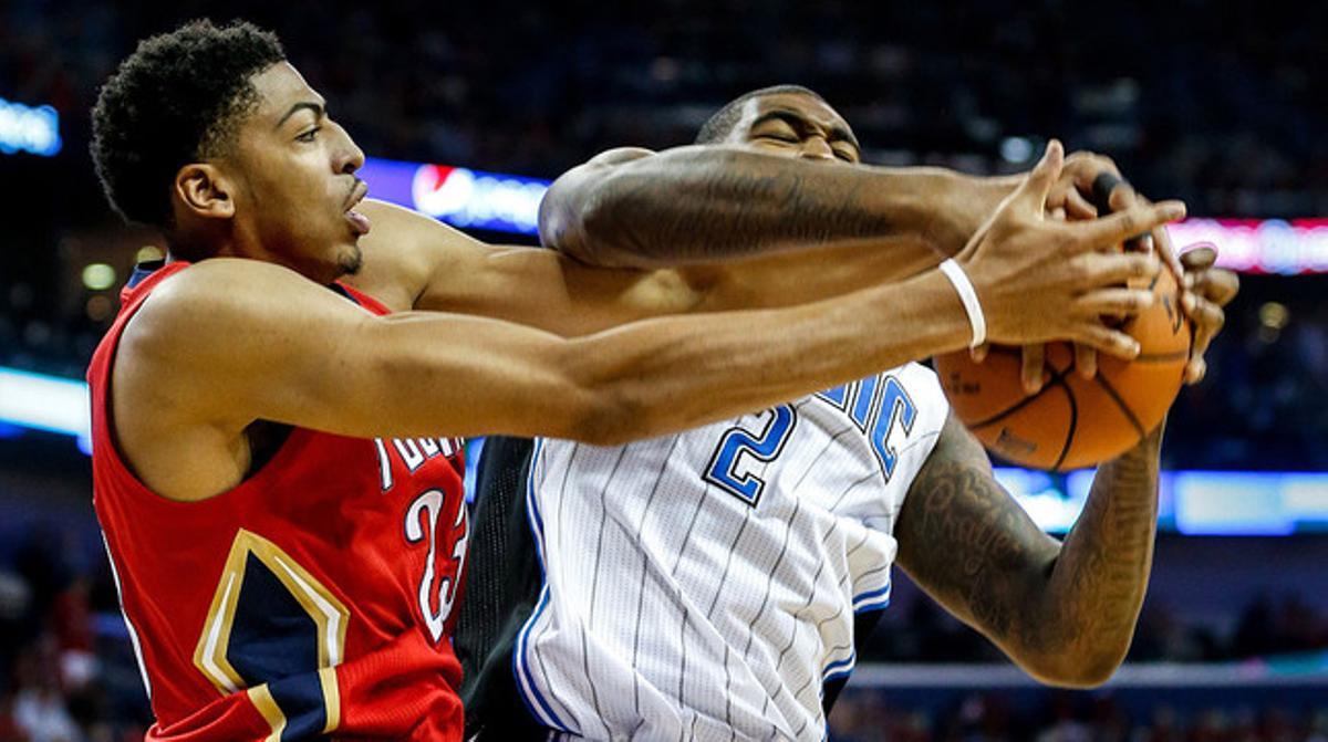 Anthony Davis (izquierda) y Kyle O’Quinn pugnan por un balón en el partido entre los Pelicans y los Magic.