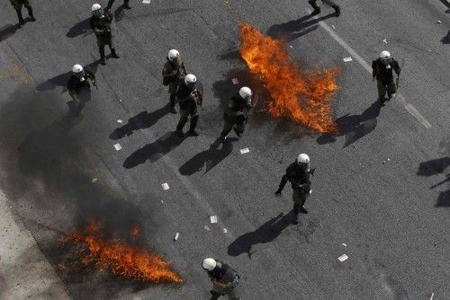 Greek riot police avoid flames from two molotov cocktails during a protest march by Greece's Communist party in central Anthens during a 24-hour labour strike