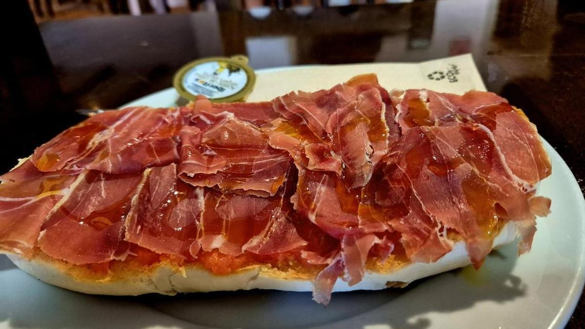 Tostada de pan con jamón y aceite.