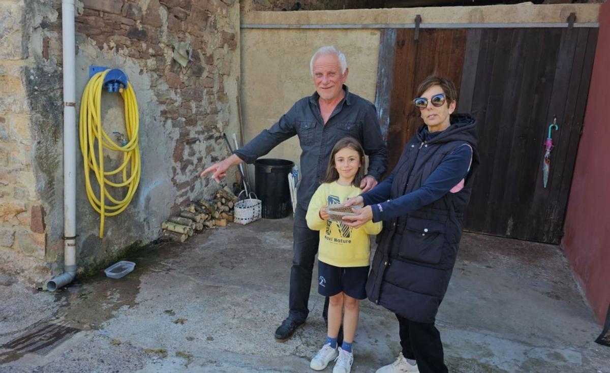 Juan Manuel Arenas señala, en presencia de Eugenia Fernández y de su hija Lola, el lugar delante de su casa donde come el zorro. | V. Alonso