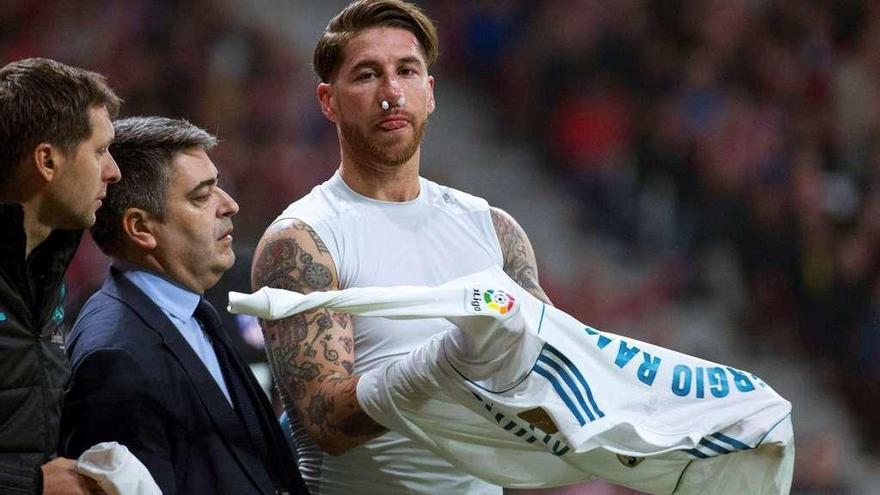 Ramos se cambia de camiseta después de recibir la patada en la cara en el Metropolitano. // Efe