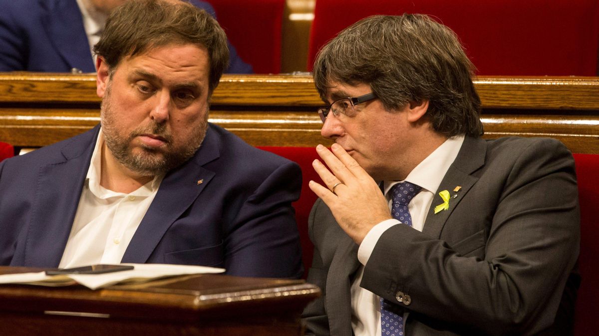 El 'exvicepresident' Oriol Junqueras y el 'expresident' Carles Puigdemont, en el hemiciclo del Parlament, en una foto de archivo del 2017.