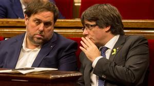 El ’exvicepresident’ Oriol Junqueras y el ’expresident’ Carles Puigdemont, en el hemiciclo del Parlament, en una foto de archivo del 2017.