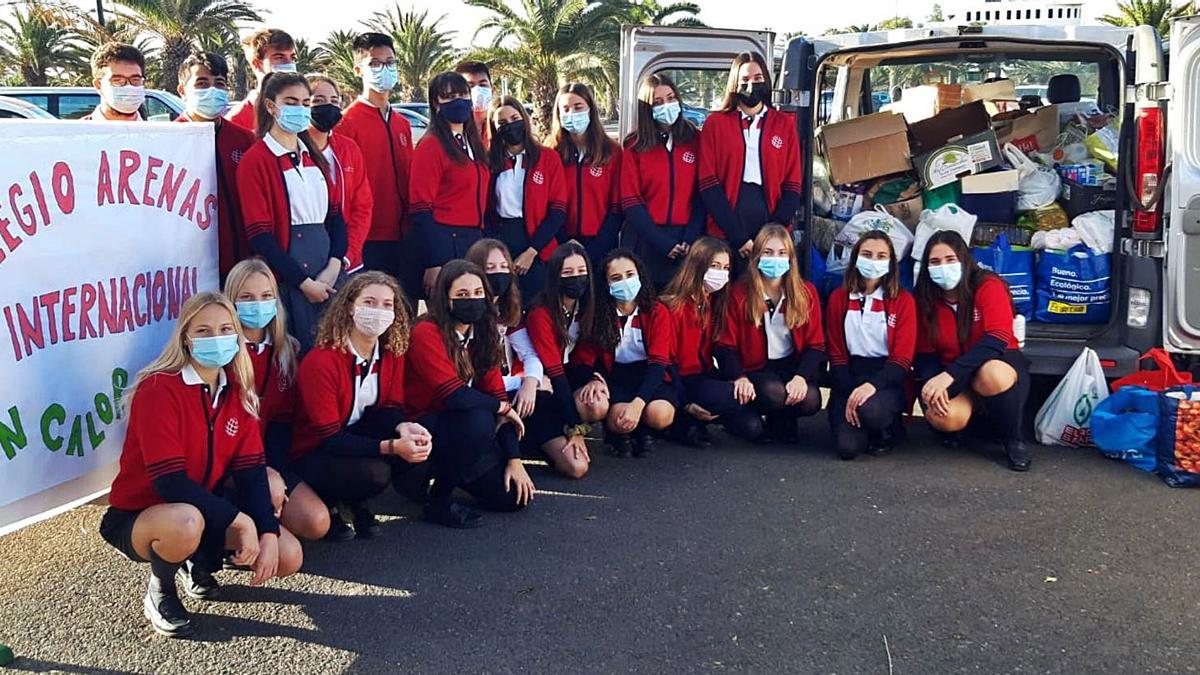 Alumnado del Colegio Arenas Internacional posa ante una de las furgonetas utilizadas para transportar los alimentos y juguetes recogidos.