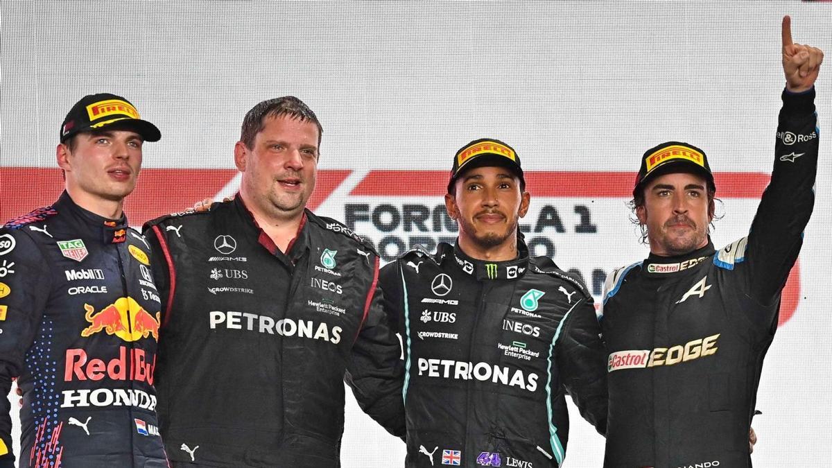Alonso, a la derecha, en el podio junto a Verstappen,  un ingeniero de Mercedes y Lewis Hamilton. // EFE