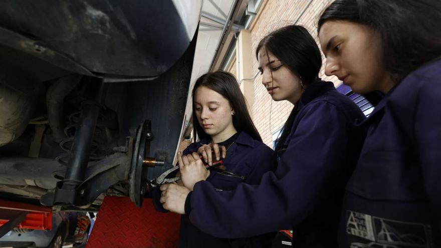 Tres alumnas tratan de desmontar un freno en el CIFP A Xunqueira.