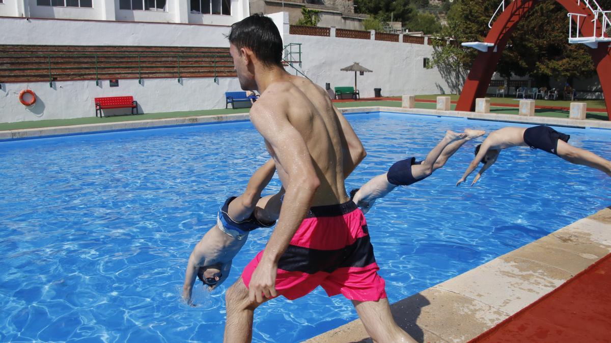 Varios jóvenes lanzándose al agua en la piscina municipal José Trenzano de Alcoy este viernes.
