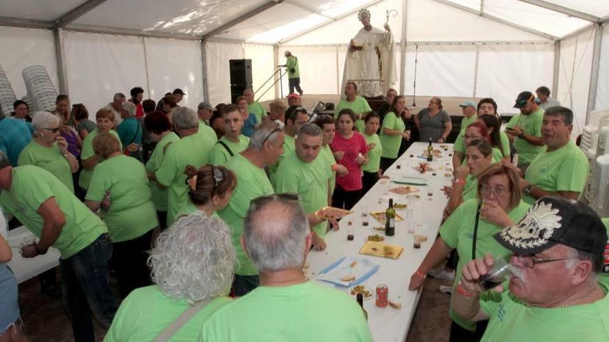 Amigos campistas disfrutando del primer aperitivo de las jornadas; al fondo, la imagen de San Ginés de la Jara.