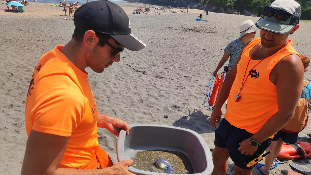 Iván Rodríguez y su compañero Marino Rubio mostrando una de las carabelas de Otur.