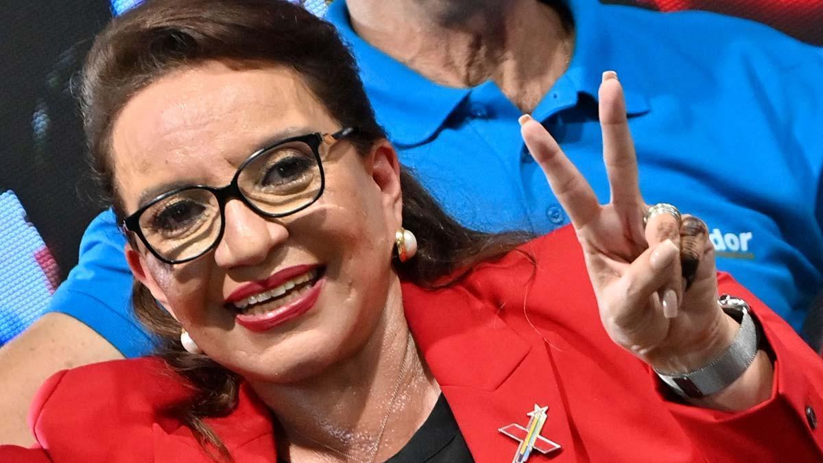 La izquierdista Xiomara Castro celebra con el signo de la victoria su ventaja en el recuento electoral.