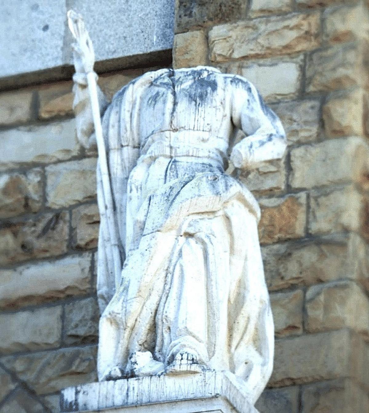 Escultura descabezada en la fachada de la iglesia.