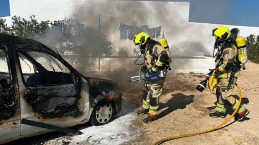 Dos bomberos apagan un coche incendiado. | CIF