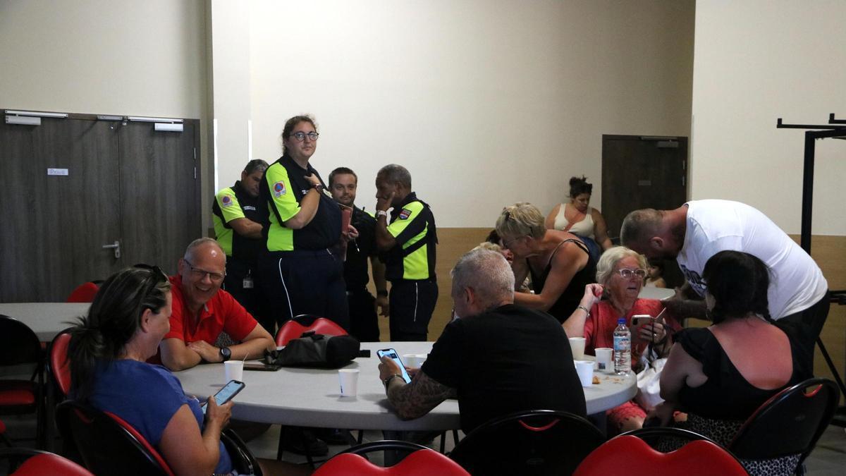 Afectats en una taula amb agents de policia al fons .