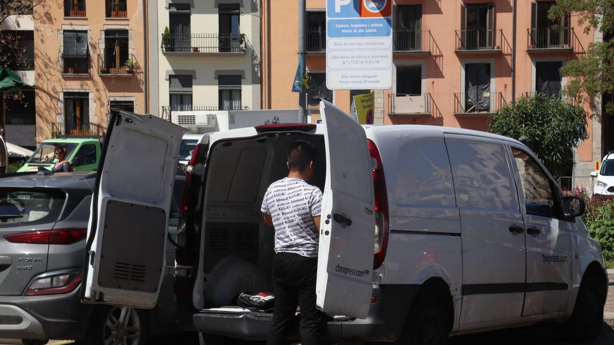Un transportista, descarregant material a la plaça Catalunya de Girona.