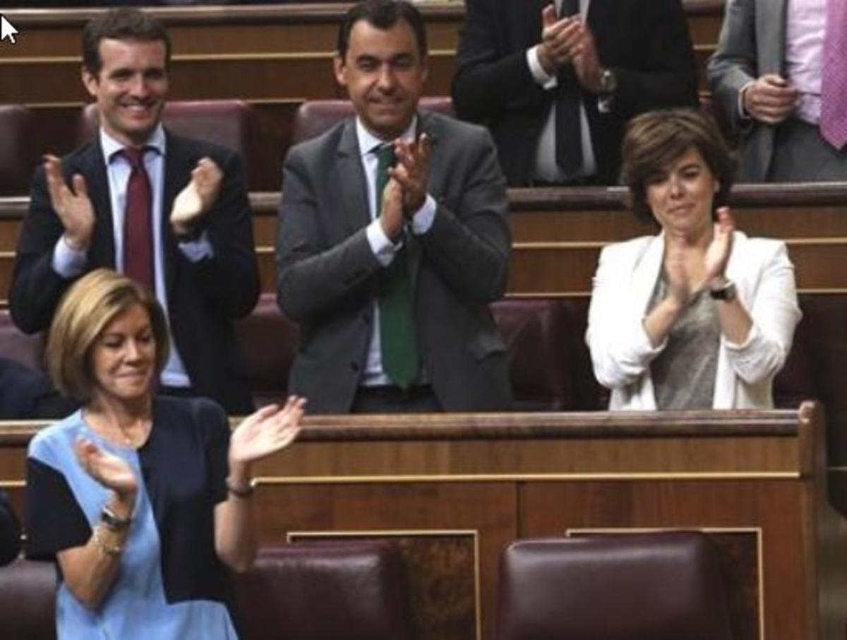 Pablo Casado, María Dolores de Cospedal y Soraya Sáenz de Santamaría, en el pleno de este martes en el Congreso, aplauden al portavoz del grupo del PP, Rafa Hernando.