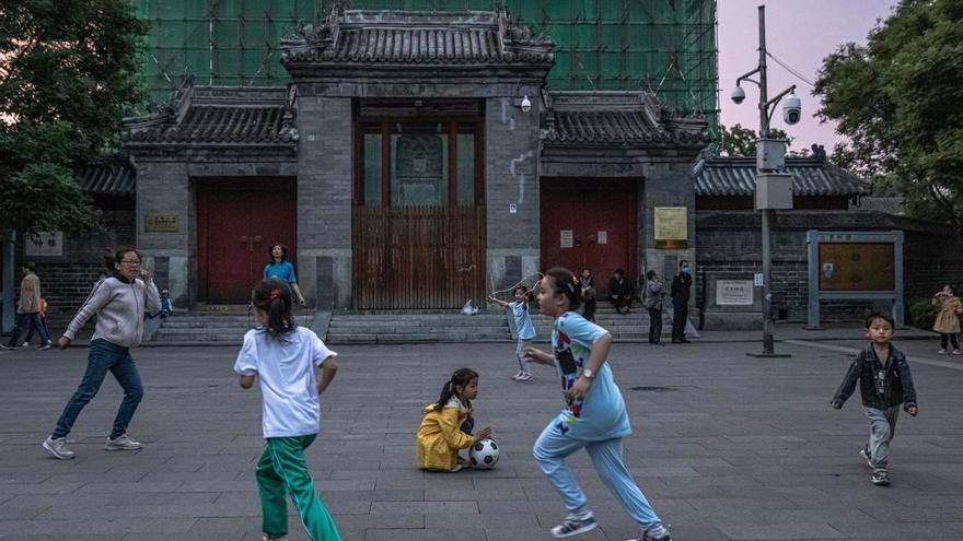 Uns nens juguen en un carrer de Pequín, la capital xinesa.