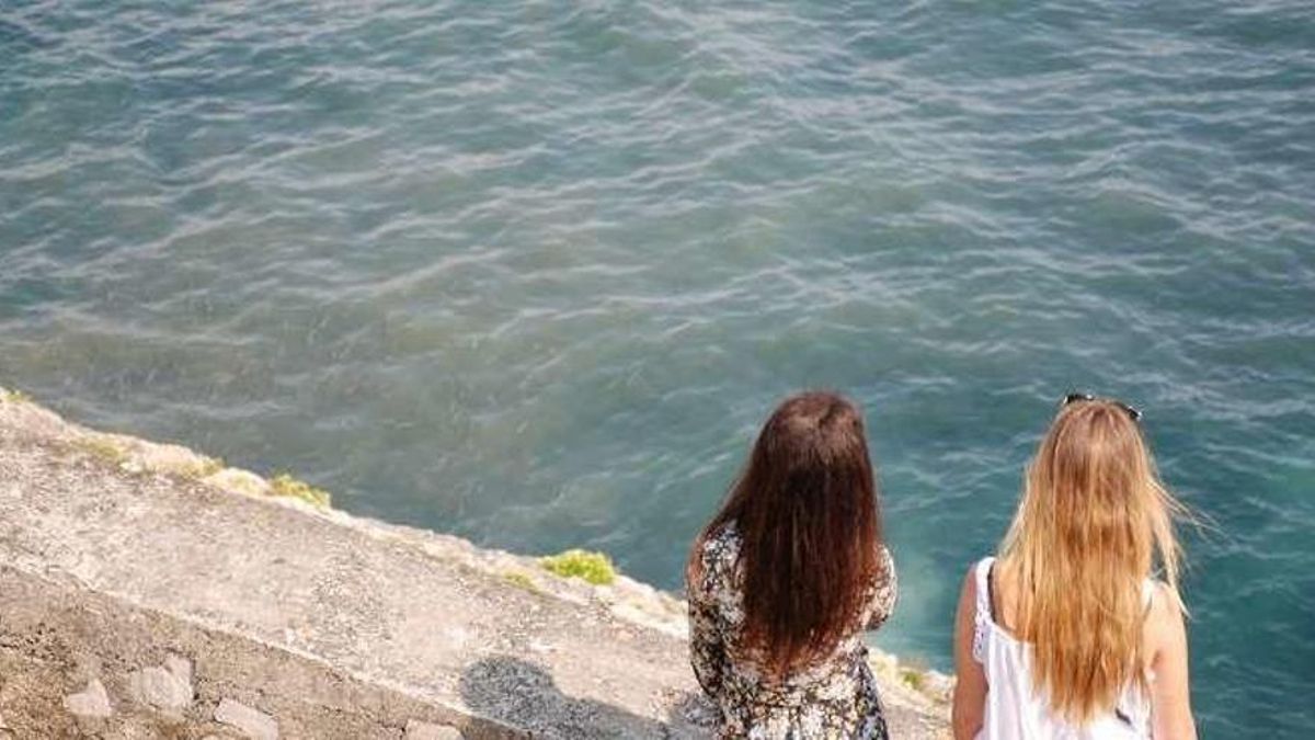 Dos turistas observan vertidos de la depuradora de El Sablón desde el paseo de San Pedro, en una imagen de archivo.