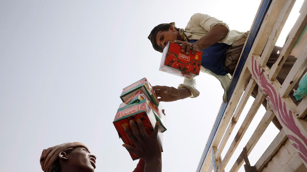 Dos personas descargan alimentos para ser distribuidos entre las personas más vulnerables, en la provincia portuaria de Hodeidah, Yemen.