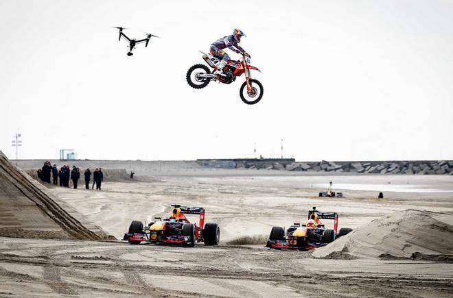 Motos y coches de carreras del equipo Red Bull circulan por la playa de Scheveningen, Países Bajos, durante la grabación de un anuncio.