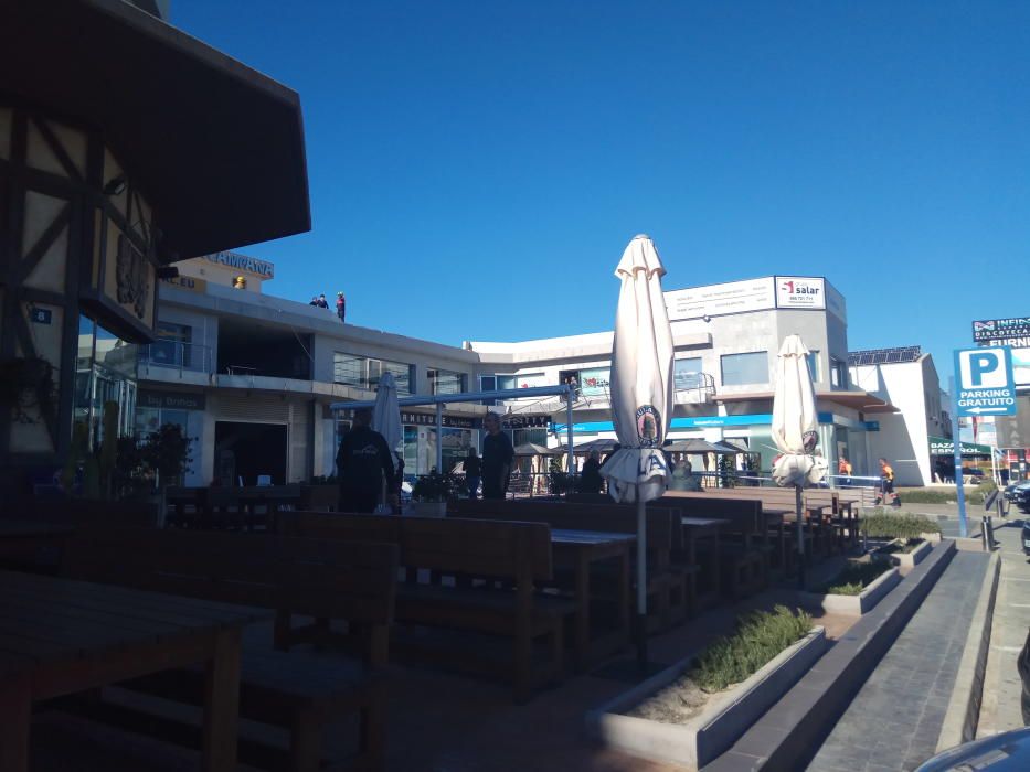 El viento derriba un cartel de grandes dimensiones sobre la terraza de un centro comercial en Orihuela Costa sin causar víctimas