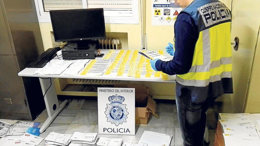 Un policía junto a la correspondencia no repartida presuntamente por el detenido en Alcoy.